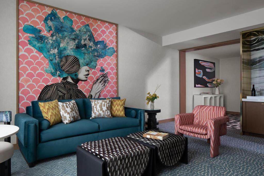 オーランドにあるLake Nona Wave Hotelのリビングルーム(青いソファ、絵画付)