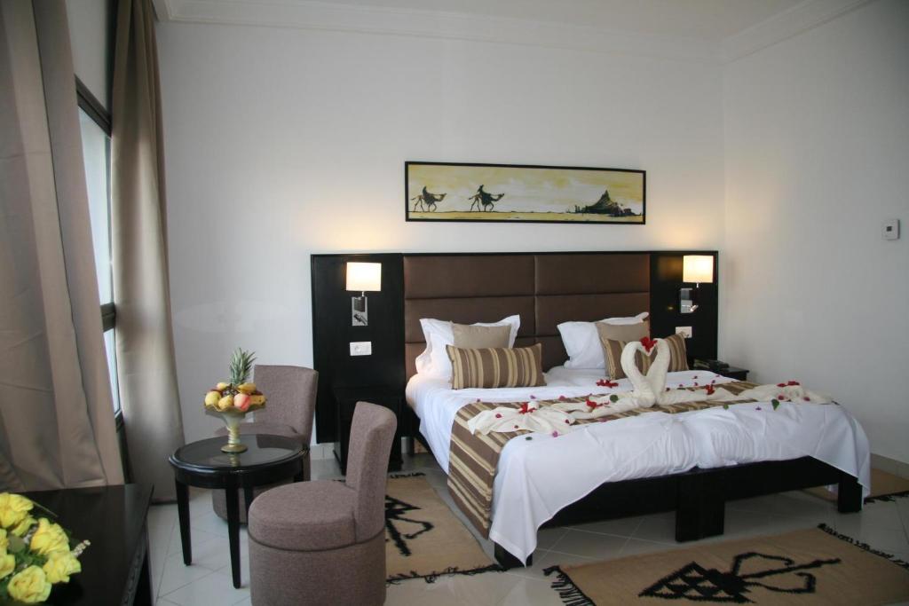 HOTEL OLYMPIC DJERBA في Djerba: غرفة فندقية بسريرين وكرسي