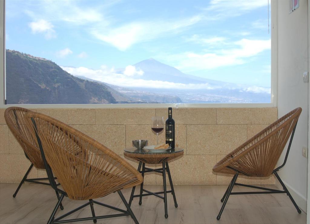 een tafel met een fles wijn en twee stoelen bij Salitre Suite 2 in Tacoronte