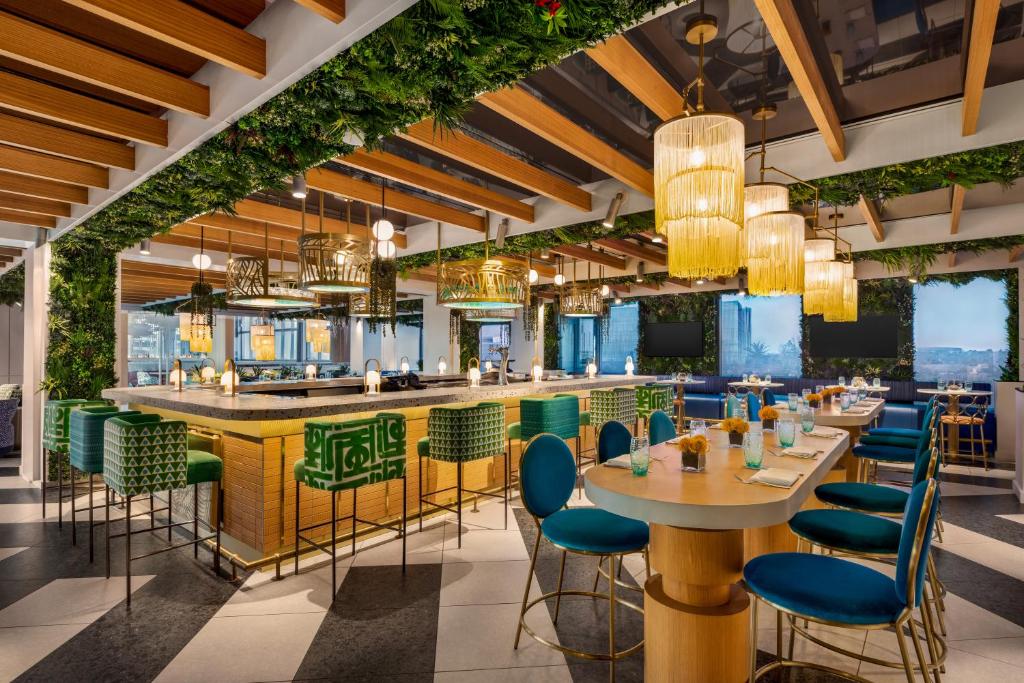 オーランドにあるLake Nona Wave Hotelのテーブルと椅子とバーのあるレストラン