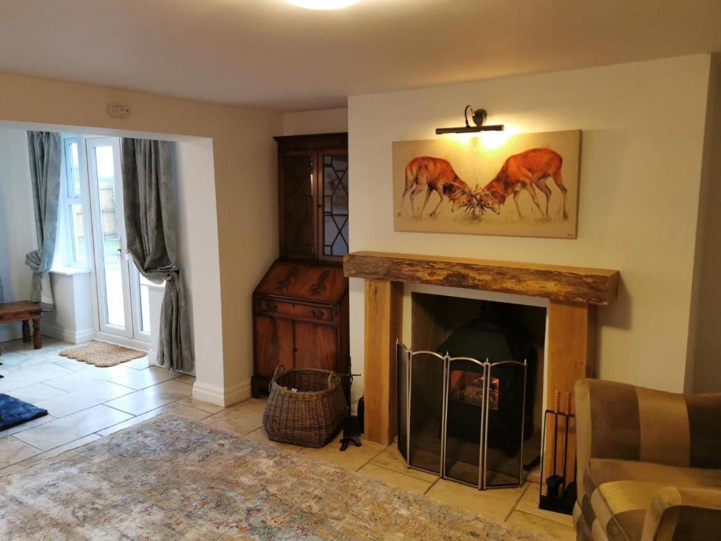 a living room with a fireplace with a picture of horses at Luxury Tranquil Cottage with Hot tub, Log burner and Jacuzzi Bath in Alford