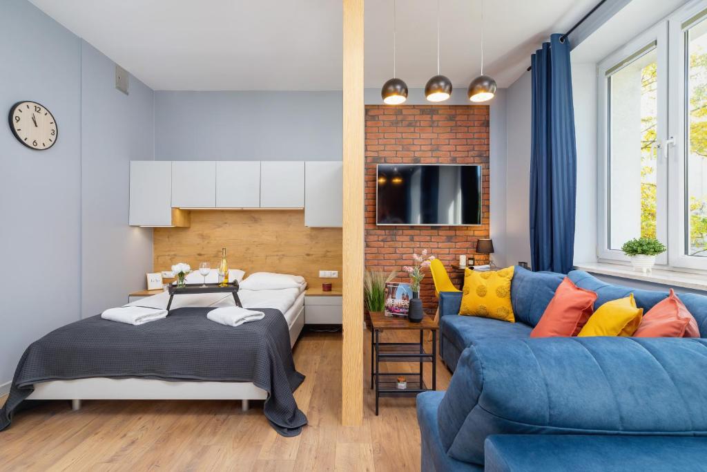 a living room with a blue couch and a bed at Kraków Trendy Studio Apartments by Renters in Krakow