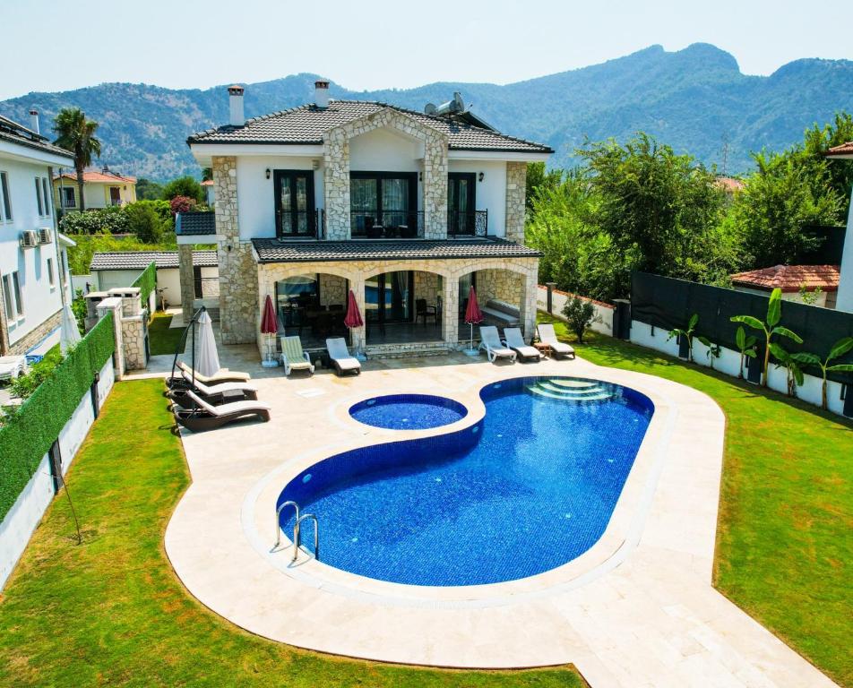 a swimming pool in the backyard of a house at Villa-Sleeps 9-Parking-Pool-Bbq-Hot tub-Pets in Dalyan
