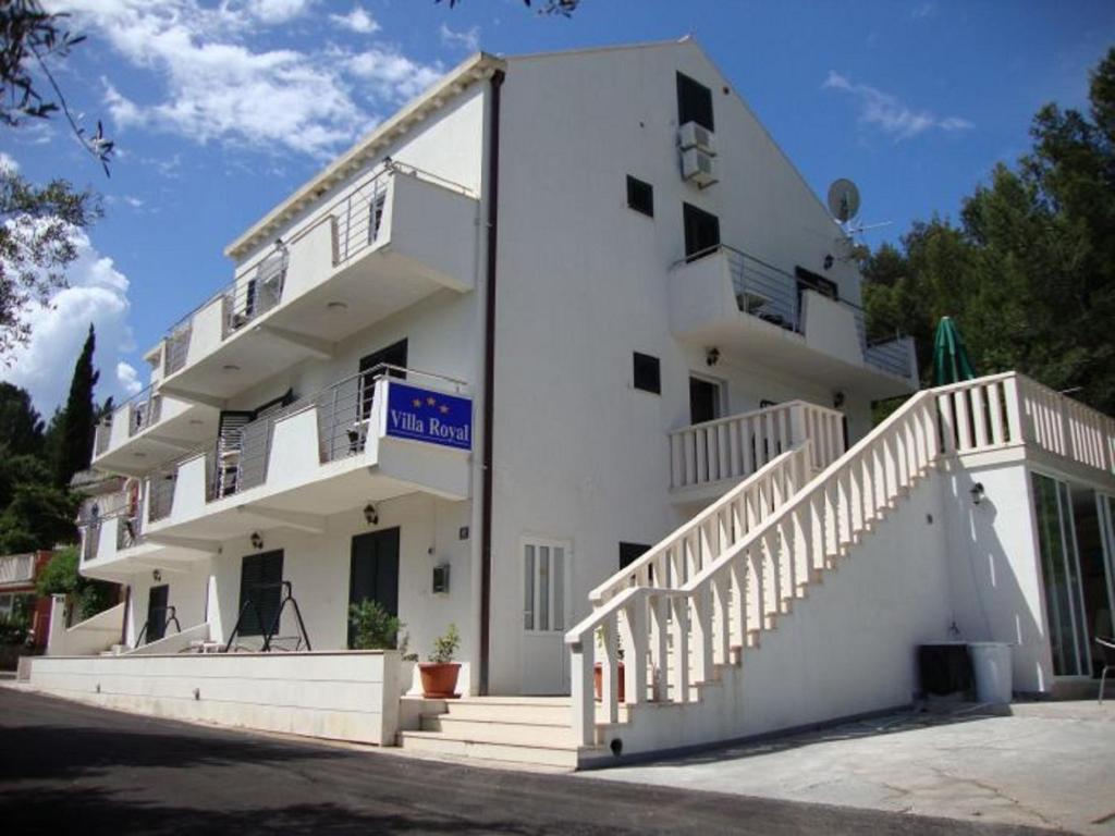 a large white building with stairs on the side of it at Villa Royal in Cavtat