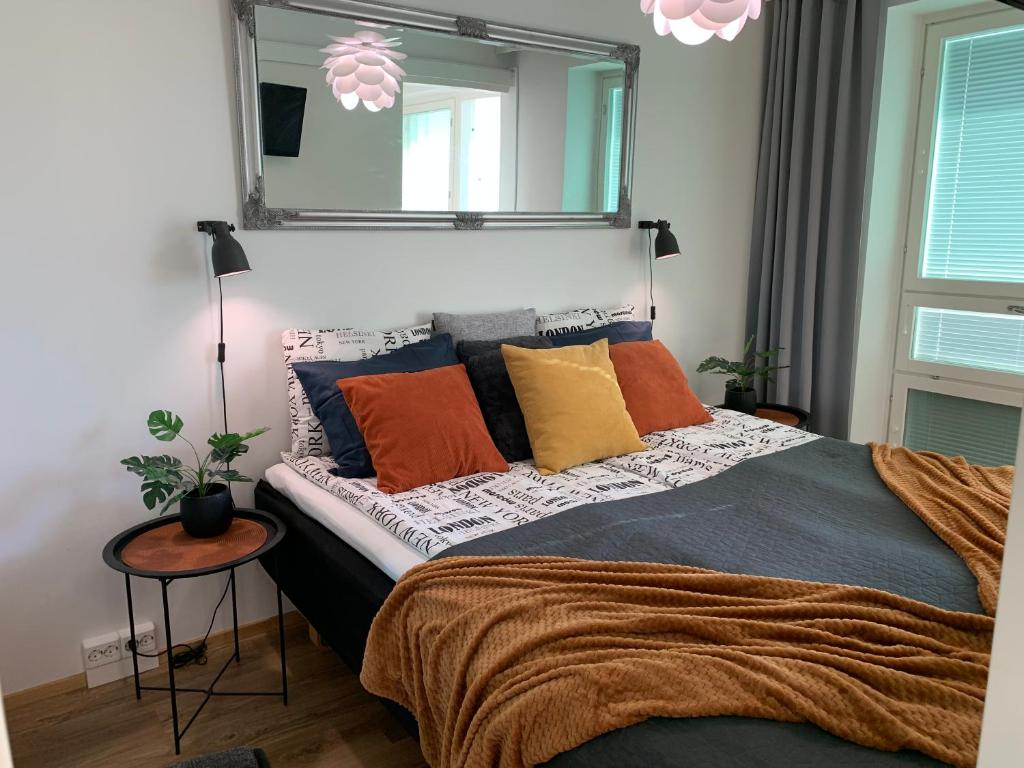 a bedroom with a large bed with colorful pillows at StarHomes Studio Lux 10 in Oulu