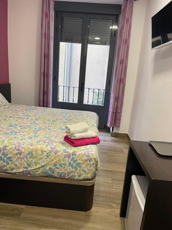 Cama o camas de una habitación en Hostal Corazón de Madrid