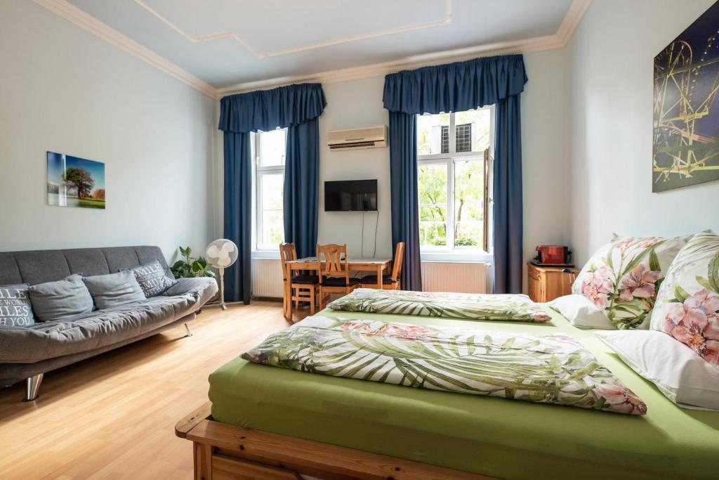 a bedroom with a bed and a couch at Pension Primavera in Vienna