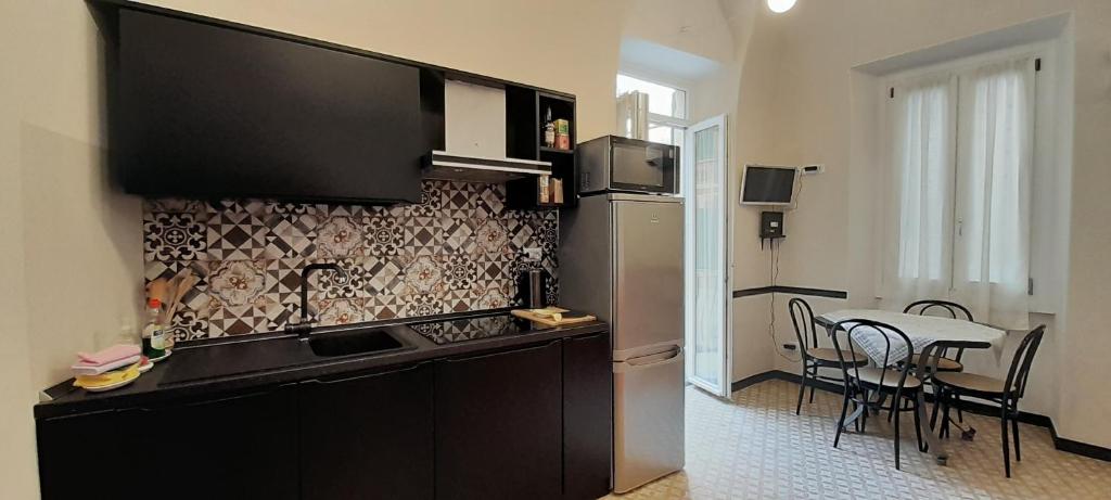 a kitchen with a counter and a table with chairs at Il Geranio in Finale Ligure