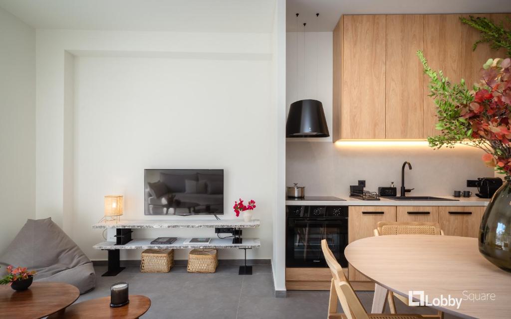 a kitchen with a table and a kitchen with a tv at La Mer Apartment by LobbySquare in Piraeus