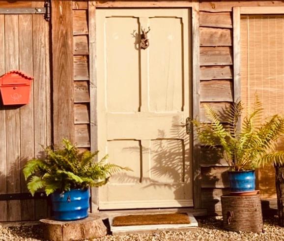 uma porta branca com dois vasos de plantas em frente a uma casa em Studio 23 