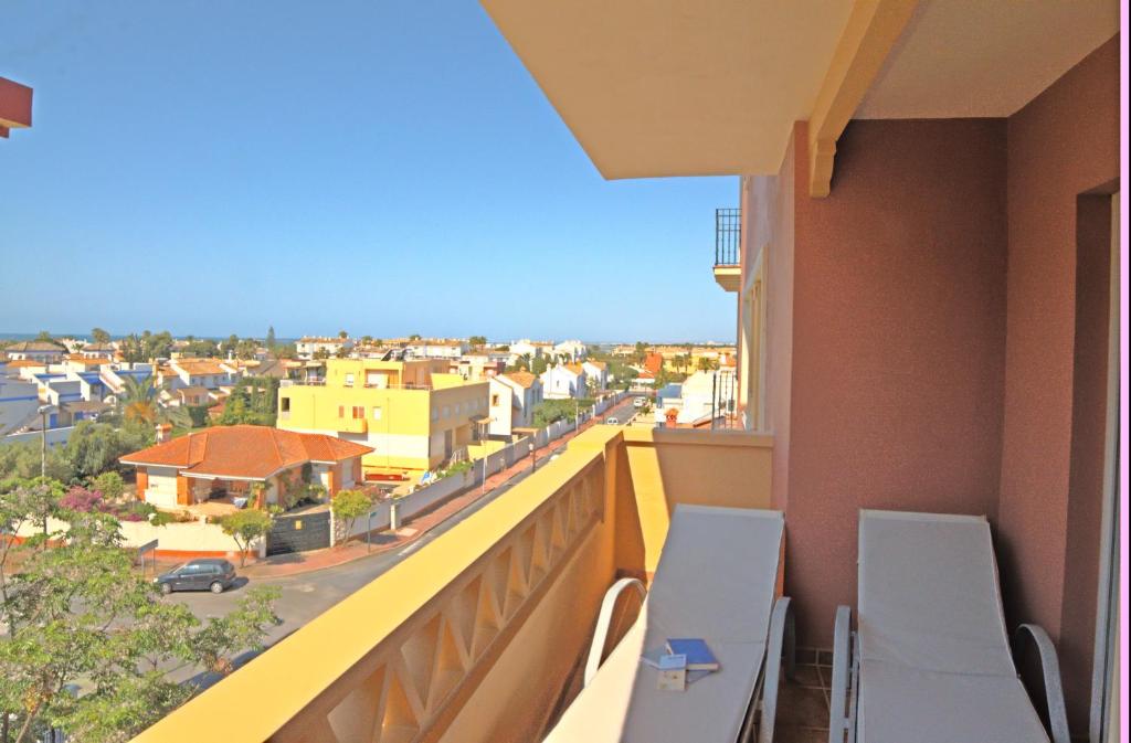 a balcony with chairs and a view of a city at Leo Canela in Isla Canela