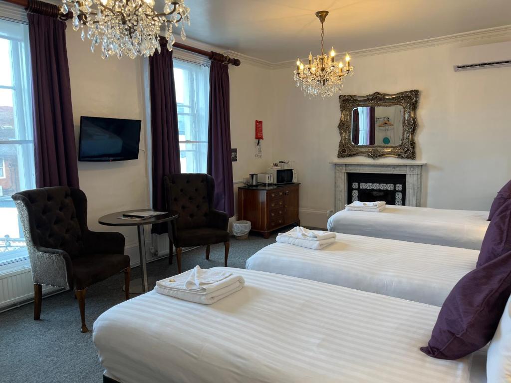 Habitación de hotel con 2 camas y chimenea en Kings Hotel en Newmarket