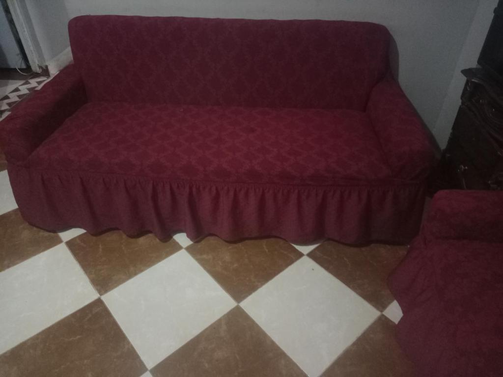 a purple couch sitting on a checkered floor at Zeina in Minshāt Kamāl
