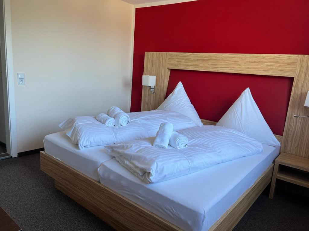 Bett mit weißer Bettwäsche und blauen Kissen in der Unterkunft Hotel Ziegenkrug - Pritzwalk in Pritzwalk