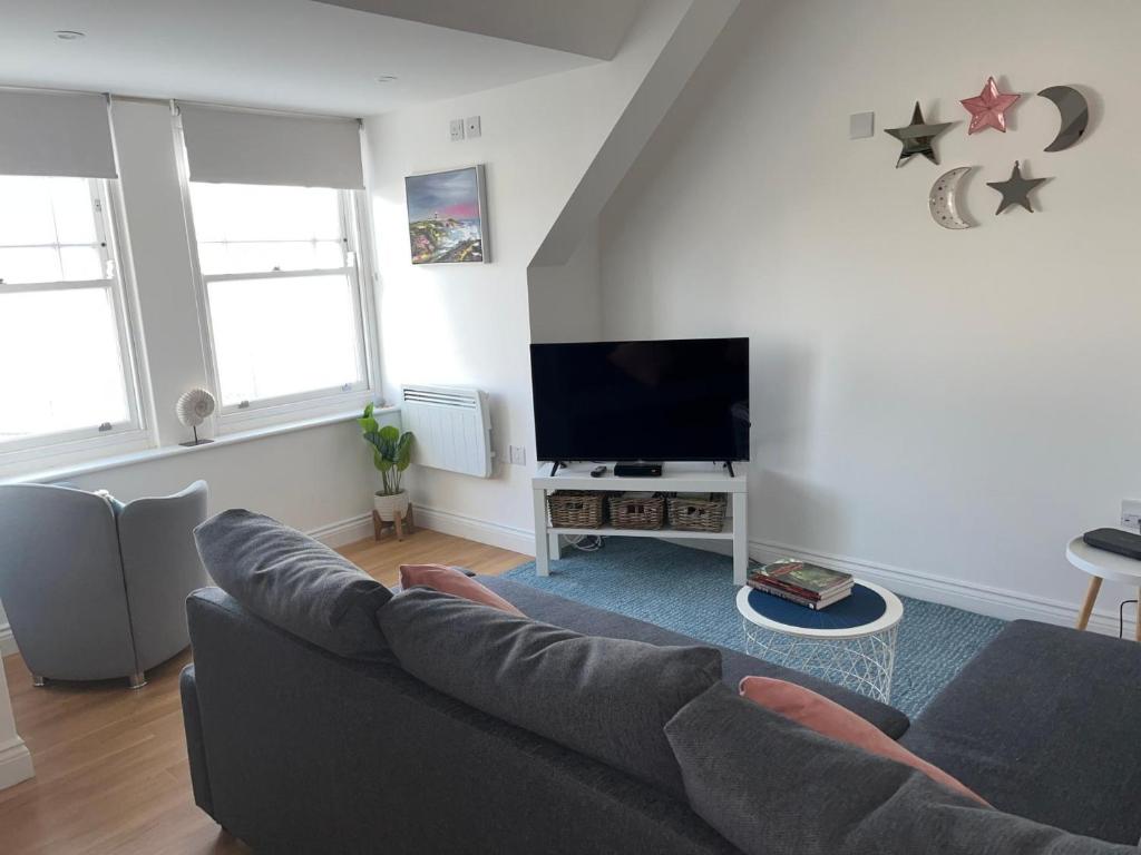 salon z kanapą i telewizorem z płaskim ekranem w obiekcie Apartment - Centre of Swanage Stunning Sea views w mieście Swanage