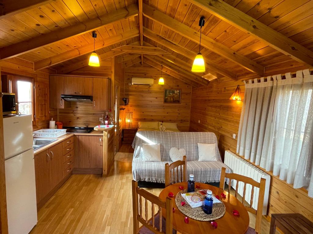a kitchen and living room in a log cabin at Cabañas El Descansito in Chillarón de Cuenca