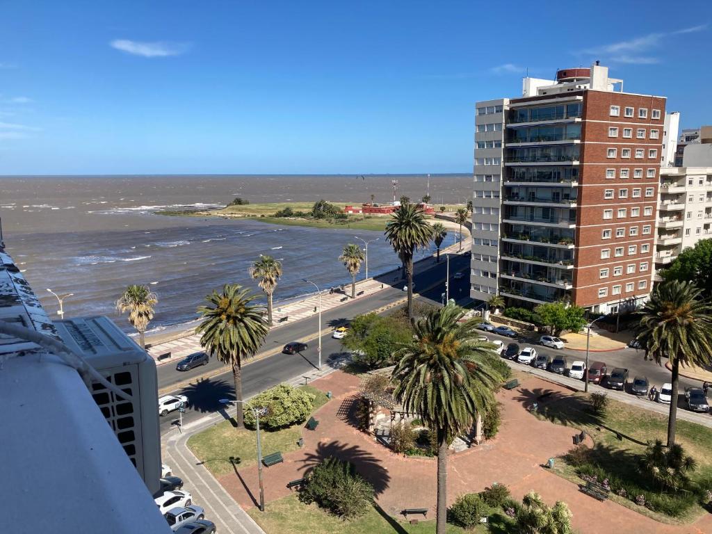 a view of a city with palm trees and the ocean at Rambla Apart in Montevideo