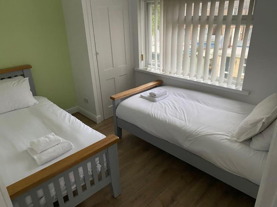 a bedroom with two beds and a window at Pontymister Retreat in Risca