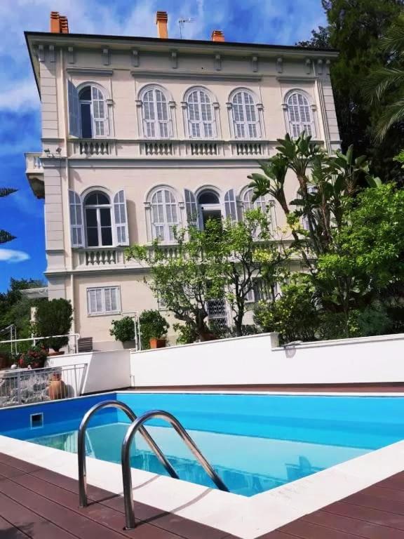 a house with a swimming pool in front of a building at Pergolato suite in Sanremo