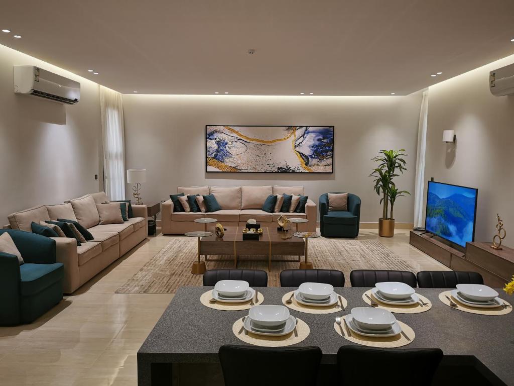 شقة راقية بثلاث غرف نوم ودخول ذاتي في الرياض: غرفة معيشة مع أريكة وطاولة