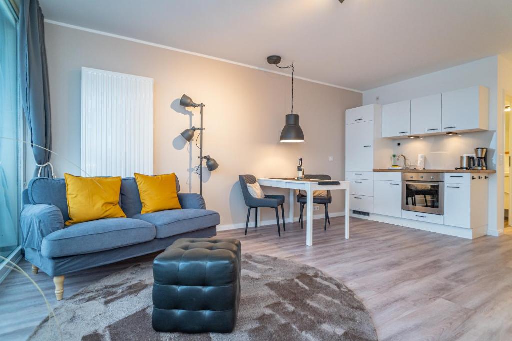 a living room with a blue couch and a table at Bismarck-Koje in Westerland