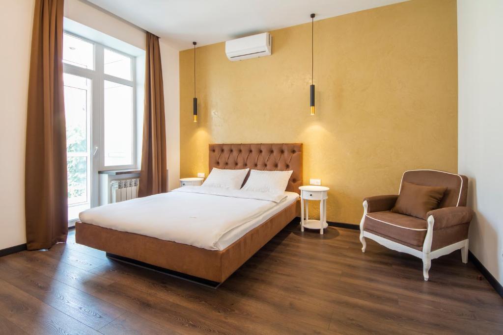 ein Schlafzimmer mit einem Bett und einem Stuhl in der Unterkunft Central Apartments Palats Sportu Area in Kiew