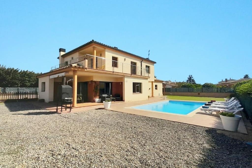 a house with a swimming pool in front of it at Villa Mediterránea con Cinco Dormitorios y Piscina in Calonge