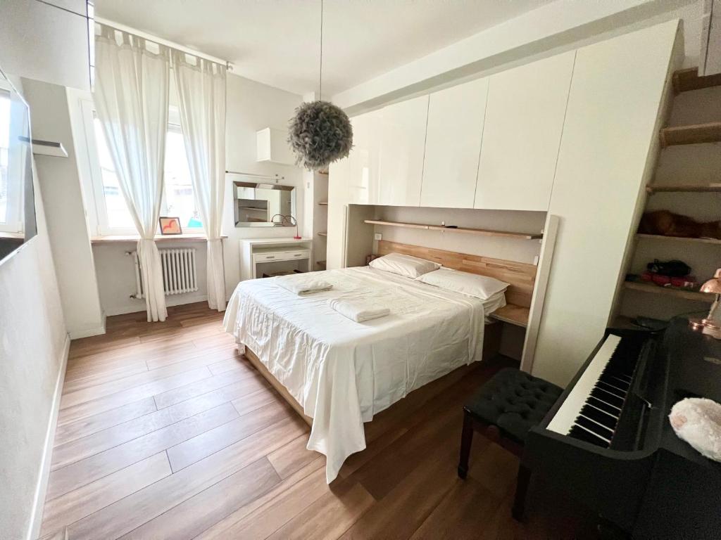 a bedroom with a white bed and a piano at white home near Linate in Segrate
