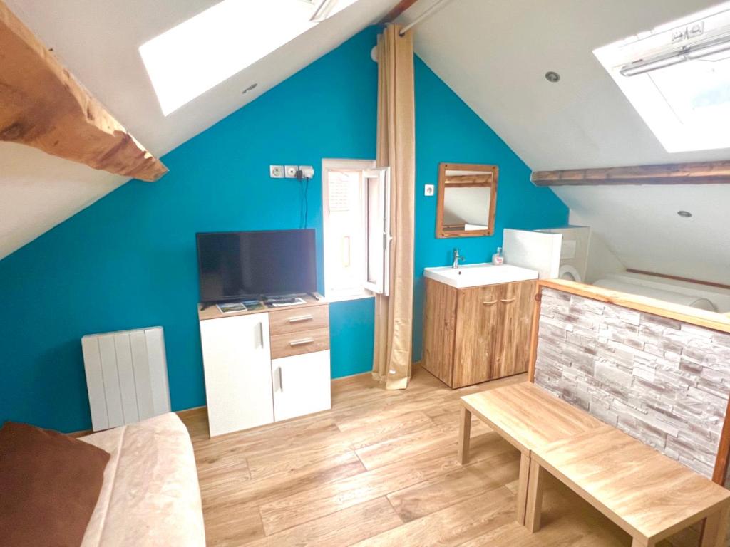 a bedroom with a blue wall and a sink and a table at delille pere et fils in Albertville