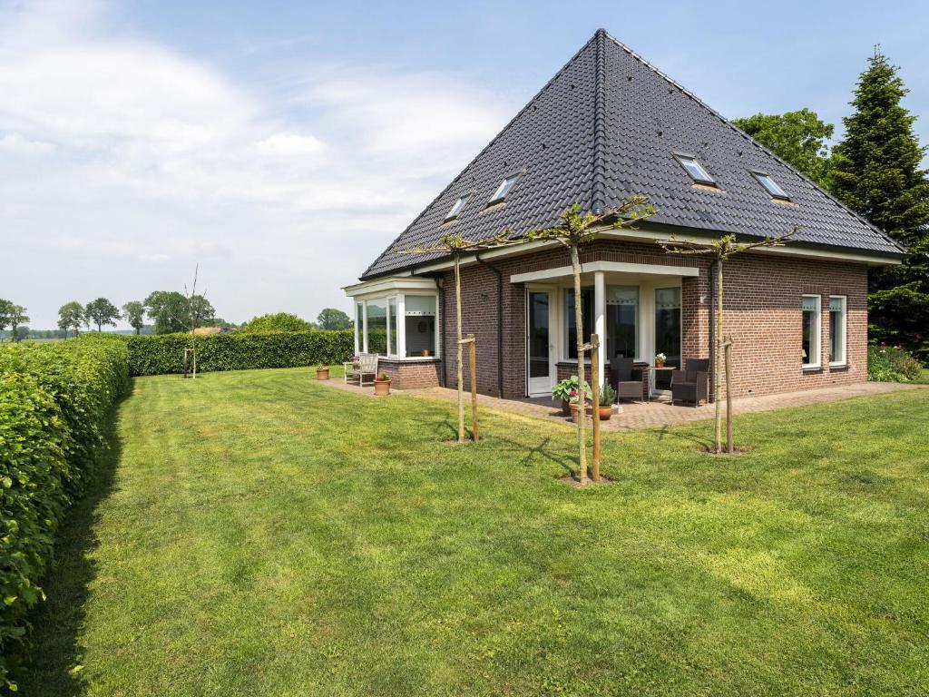 een klein bakstenen huis met een grote tuin bij Holiday home with wide views and garden in Balkbrug