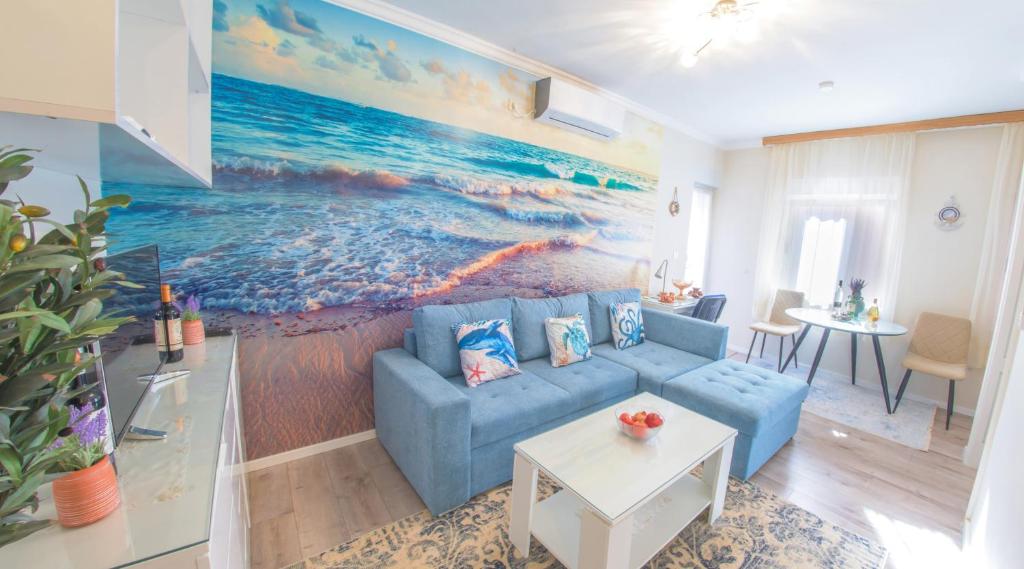 a living room with a blue couch and a painting of the ocean at Luka-Mostar Free Parking in Mostar