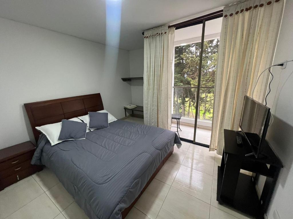 Schlafzimmer mit einem Bett und einem Flachbild-TV in der Unterkunft Hotel Playa Blanca in Tota