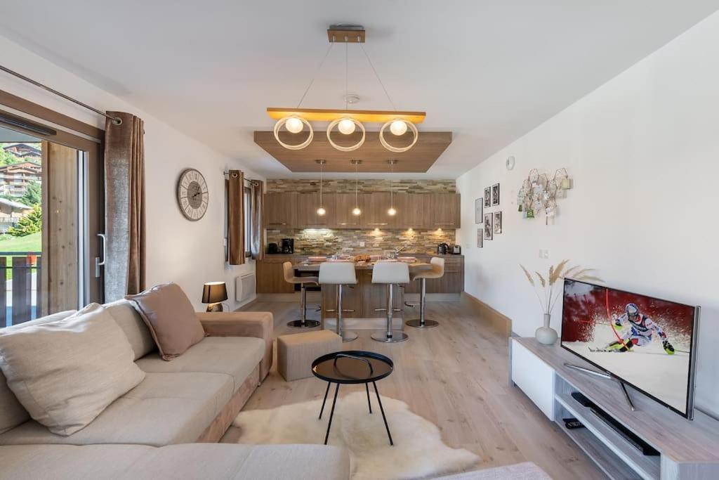 een woonkamer met een bank en een eetkamer bij Les 4 Elements - Apt A11 - BO Immobilier in Châtel
