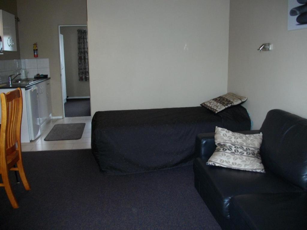 a living room with a couch and a kitchen at Sun Valley Motel in Wellsford