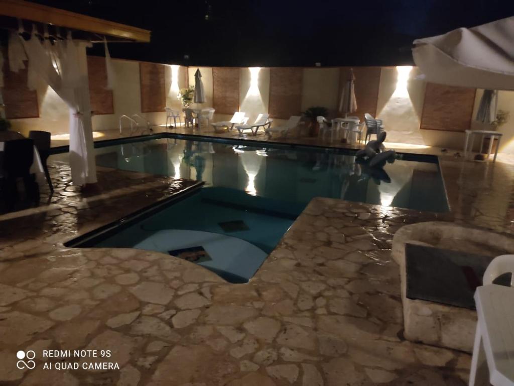 a large swimming pool in a hotel room with a pool at Hotel Boutique Los Gentiles in Santa Fe de Antioquia