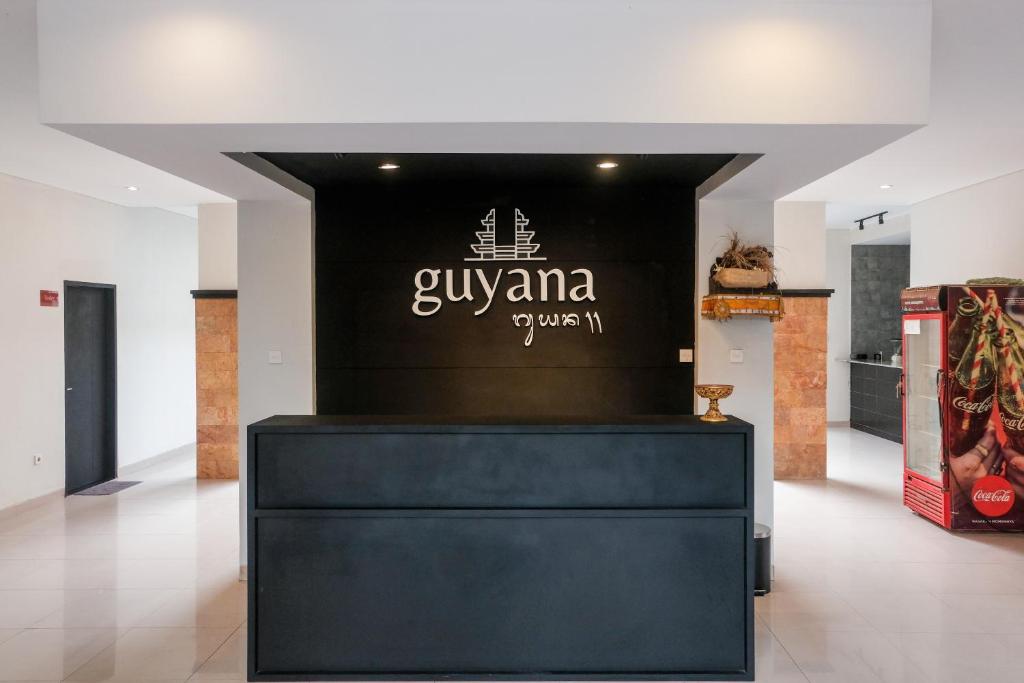 a store with a black and white sign on a wall at Guyana Hotel in Kuta