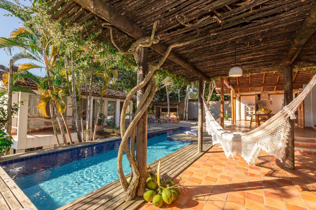 a resort with a hammock and a swimming pool at Casa Caminho do Mar (TRANCOSO-BA) in Trancoso