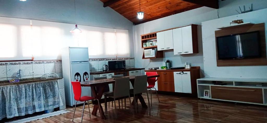 a kitchen with a table and red chairs in a room at Incrivel chacara com pisc e churrasq em Extrema MG in Extrema