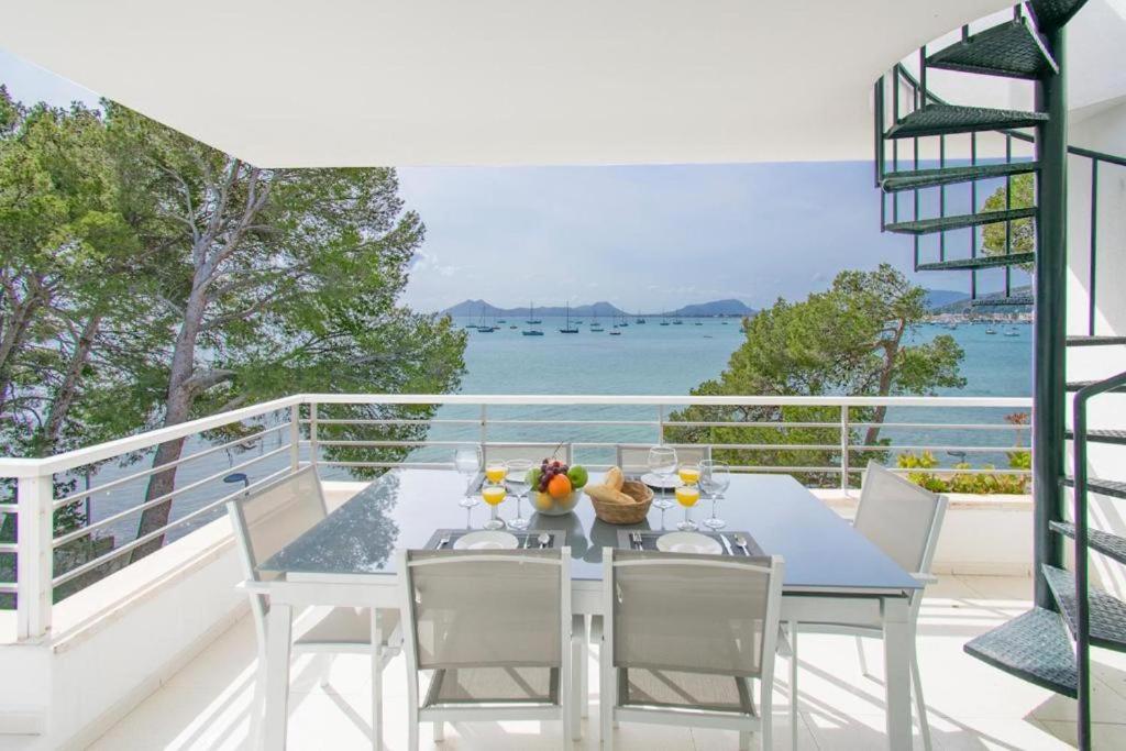 a dining table on a balcony with a view of the ocean at Isabela 2a 3 habitaciones con ático in Port de Pollensa