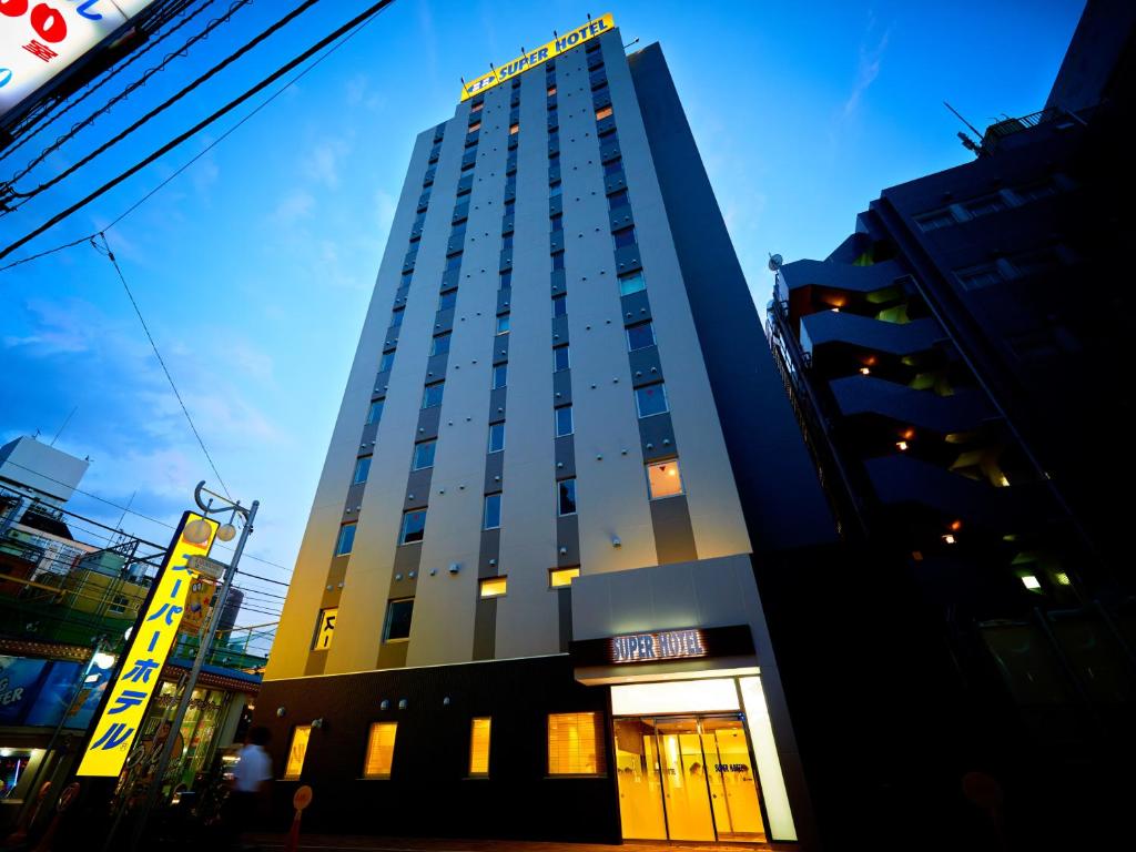 a tall building with its doors open in a city at Super Hotel Shinjuku Kabukicho in Tokyo