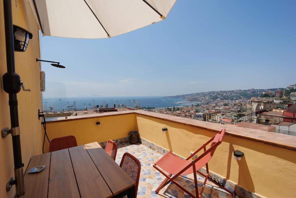 un tavolo e sedie su un balcone con vista di Chiaia Stunning SeaView StudioFlat with 2 Terraces By HouseinNaples a Napoli