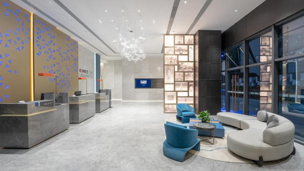 成都市にあるHoliday Inn Express Chengdu Pidu, an IHG Hotelのロビー(白いソファ、青い椅子付)