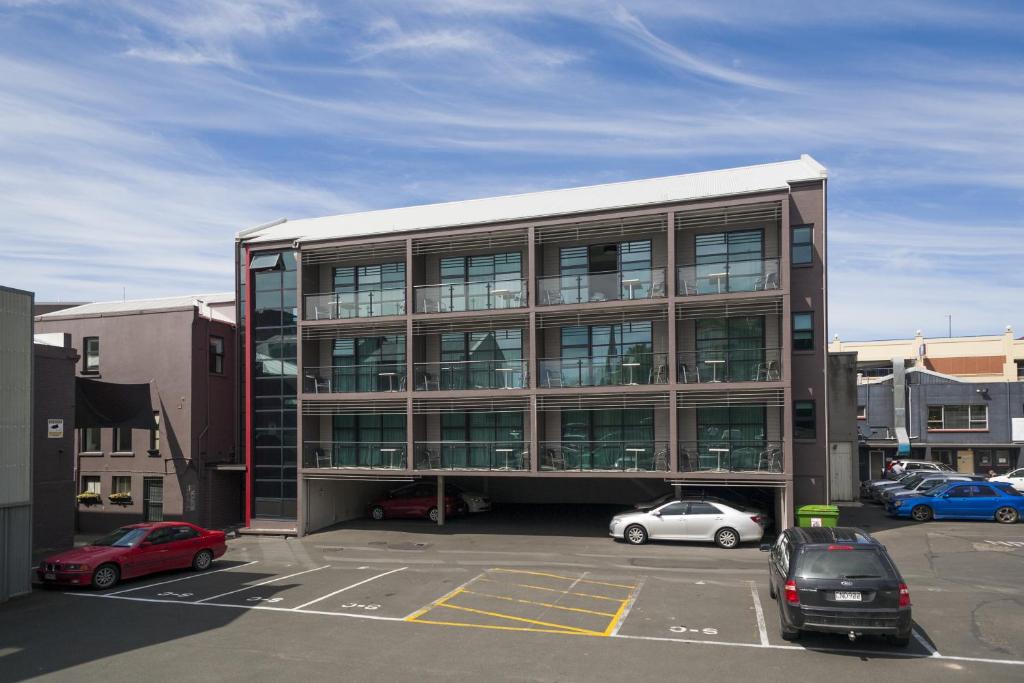 un gran edificio con coches estacionados en un estacionamiento en 315 Euro Motel and Serviced Apartments, en Dunedin