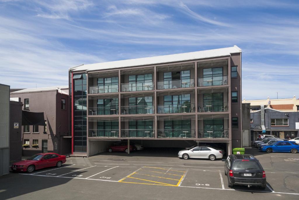 a large building with cars parked in a parking lot at 315 Euro Motel and Serviced Apartments in Dunedin