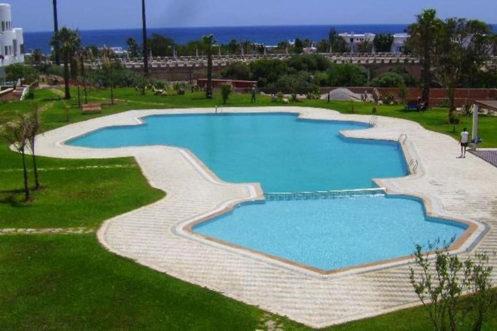 una gran piscina en un campo de césped en SUPERBE appart 2 ch au résidence balnéaire colina smir, en M'diq