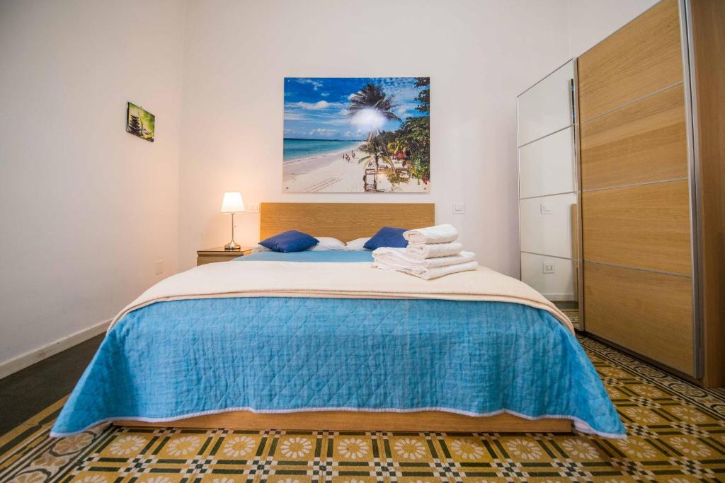 Un dormitorio con una cama grande con una manta azul. en Bed&Breakfast Salerno, en Salerno