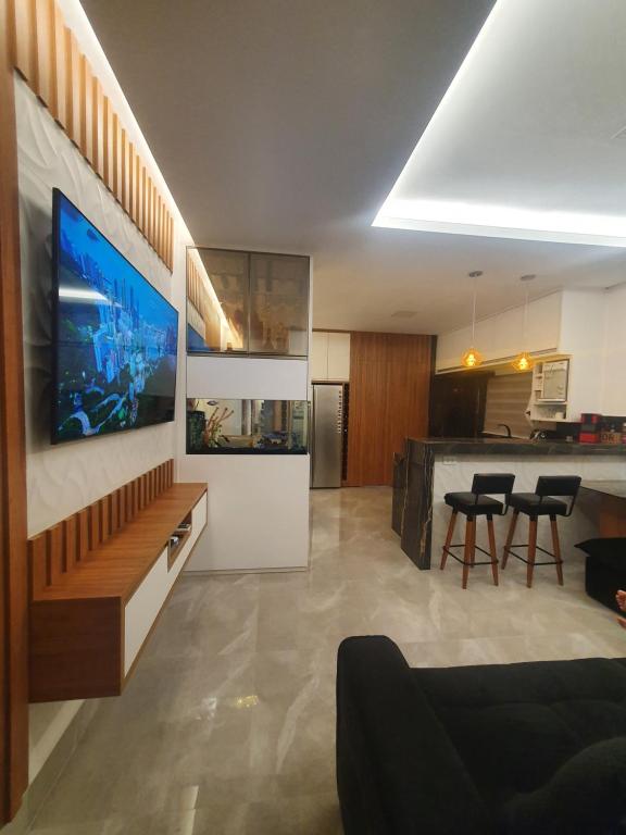 a living room with a couch and a kitchen at Residencial Goulart in Capitólio