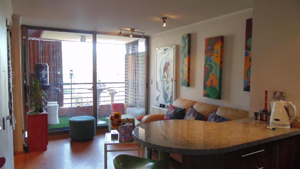 ACOGEDOR DEPARTAMENTO EN APOQUINDO في سانتياغو: غرفة معيشة مع أريكة وطاولة