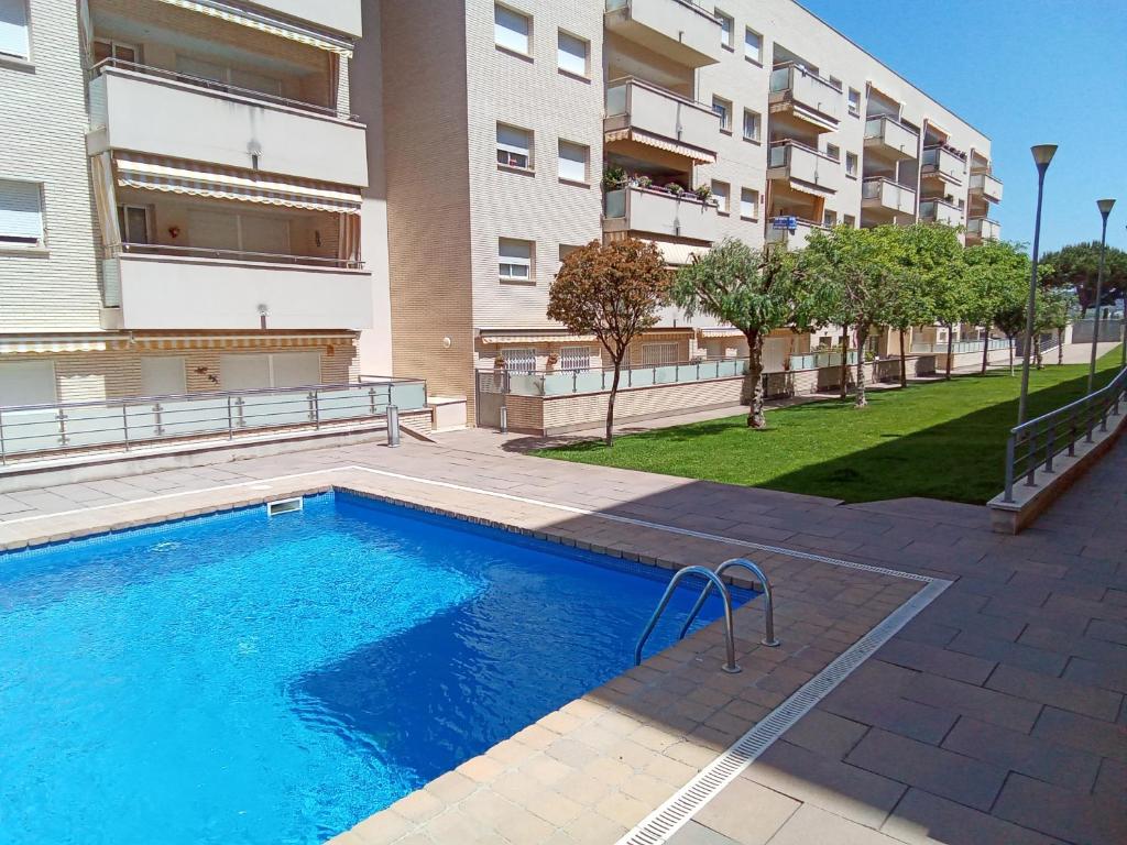 リョレート・デ・マルにあるVivalidays Alicia - Fenals - Lloret de Marのアパートメントの建物の前にスイミングプールがあります。