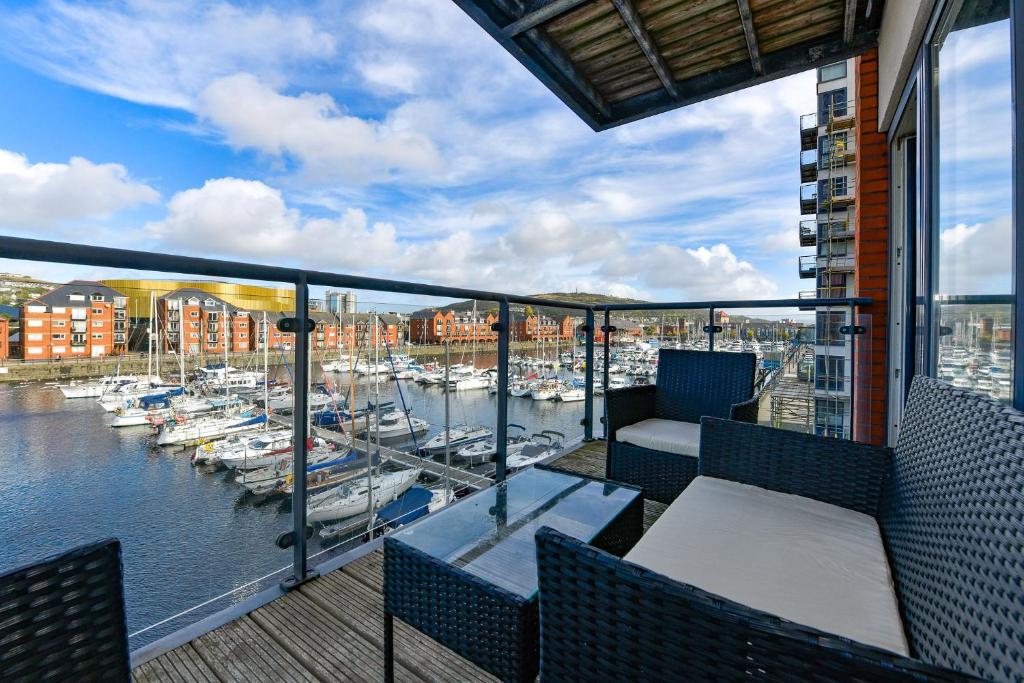 a balcony with a view of a marina with boats at Just Stay Wales - Meridian Wharf, Marina View - 2 Bed Apartment in Swansea